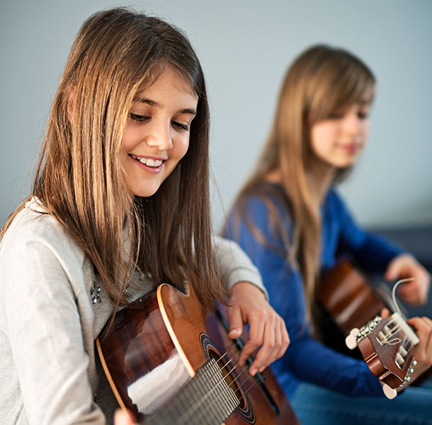 Mädchen üben Gitarre